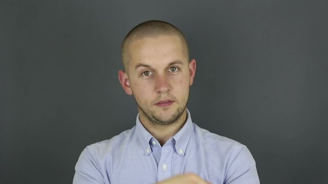 A funny, cute guy asks for a callback and makes a hand gesture. Portrait of a young guy, he makes a hand gesture next to his ear asking for a callback.