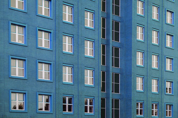 Fototapeta na wymiar Facade of office blue building with windows. Facade of an old blue brick wall with windows. Old blue brick wall with windows.
