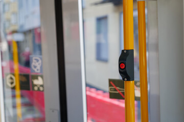 Selected focus at Red stop button in front of automatic door of light rail tram in Düsseldorf, Germany.