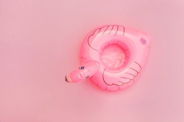 Summer beach composition. Simply minimal design with Inflatable flamingo isolated on pastel pink...