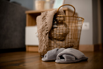 Fototapeta premium view on large metal wicker basket with knitted blanket inside