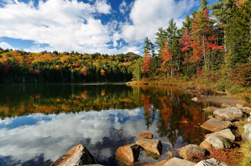 Beautiful fall foliage at Falls Pond at White Mountain, New Hampshire. The pond is located next to...