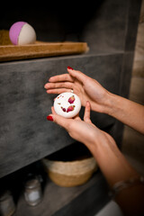 Beautiful soap with petals in the hands of woman in the bathroom.