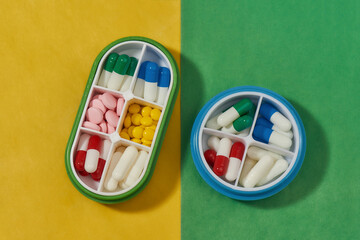 Top view of containers for pills with different medicines. Pill organizer box storing doses of...