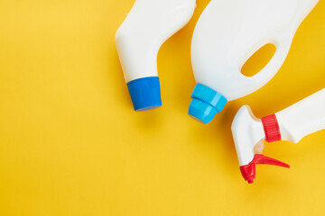 blank chemicals bottles on a bright yellow background. copy space. cleaning and washing concept.