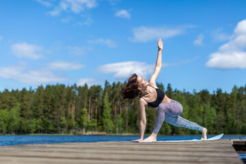 Fototapeta na wymiar Woman exercising yoga and do exercise. fitness lifestyle at the outdoors nature background. Sunny day on lake