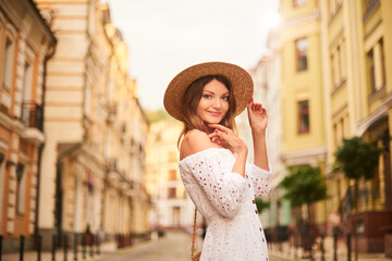 pretty woman with straw hat on head and white cotton dress on resort, holiday, vacation trip in Europe.