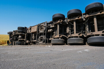 Upside down trailer truck with semi-trailer on the side of the highway