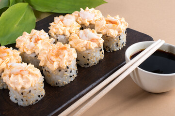 Sushi Roll with yellow cream sauce on beige background