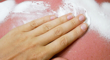 Fototapeta premium Creaming the tanned back. Smoothing cream from sunburns