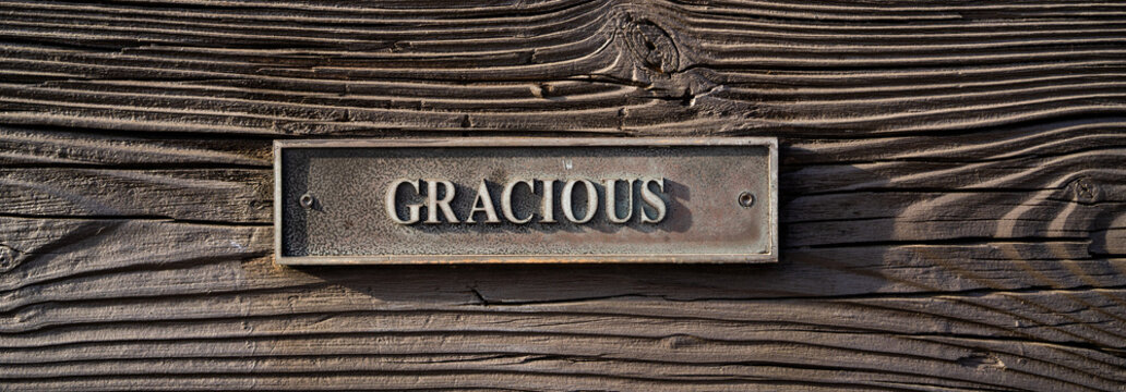 metal plaque with word gracious on wooden bench