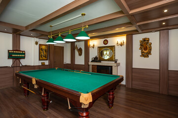 Billiard room interior. Green table for game. Old german style design. Brown wooden decor on the...