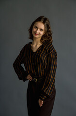 Beautiful, young brunette girl in brown clothes.  Portrait shooting in the studio.