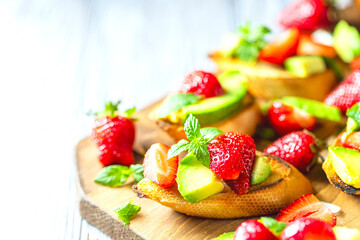 Summer snack. Delicious homemade crostini with strawberries and avocado. Proper nutrition, balanced