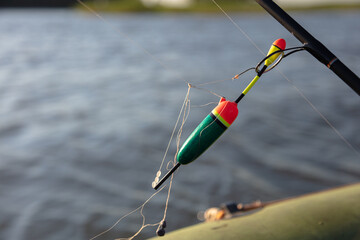 Bobber and tangled fishing line. Blurred water background.