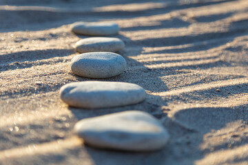Lined smooth pebbles in the sand, Copy space