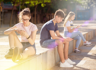 Fototapeta na wymiar Teenagers are playing on smartphone on street