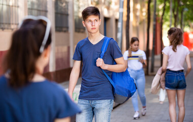Teenager walking in the street, carrying a bag on one shoulder