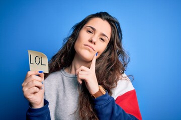 Young beautiful woman with curly hair holding reminder paper with lol message serious face thinking about question, very confused idea