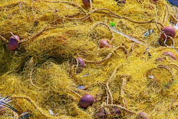 pile of colourful fishing nets with floats and ropes.