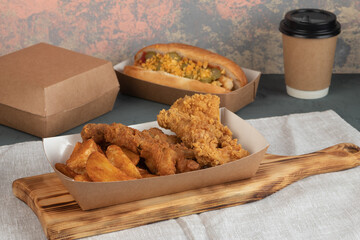 Eco packaging - potato wedges with chicken in craft packaging for the delivery service. Fast food.