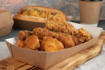 Eco packaging - potato wedges with chicken in craft packaging for the delivery service. Fast food.