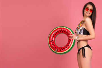 beautiful young woman in bikini,  isolated on pink background. blond girl smiling, posing with beach accessorize . beach summer concept, tropical vibe, studio shot