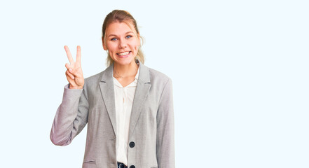 Young beautiful blonde woman wearing elegant jacket showing and pointing up with fingers number two while smiling confident and happy.