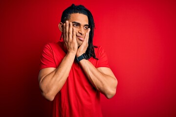 Young handsome african american afro man with dreadlocks wearing red casual t-shirt Tired hands covering face, depression and sadness, upset and irritated for problem