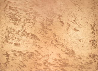 Gold colored paint with decorative texture. Decorative plaster and paint on the wall with brushed gold color.