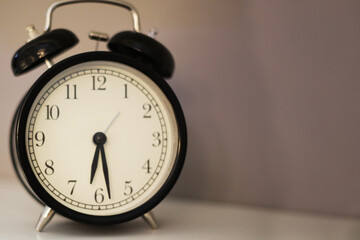 Naklejka premium black clock stands on a light background. watch with a large dial.