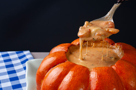 Shrimp in the pumpkin. Typical Brazilian dish, where the shrimp is made inside the pumpkin, with tomato sauce, cheese, creamy cheese and coconut milk. Selective focus