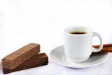 white porcelain cup with coffee and cookies isolated on white cloth with space for text