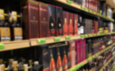 Blurred abstract background of shelf in supermarket. Alcohol showcase blurred background.