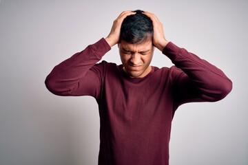 Young handsome hispanic man wearing casual shirt standing over white isolated background suffering...