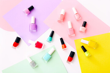 Group of nail polishes of different colors on colorful background.