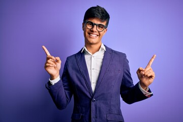 Young handsome business man wearing jacket and glasses over isolated purple background smiling confident pointing with fingers to different directions. Copy space for advertisement