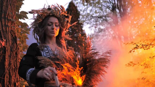A forest witch brews a potion holding a Voodoo doll