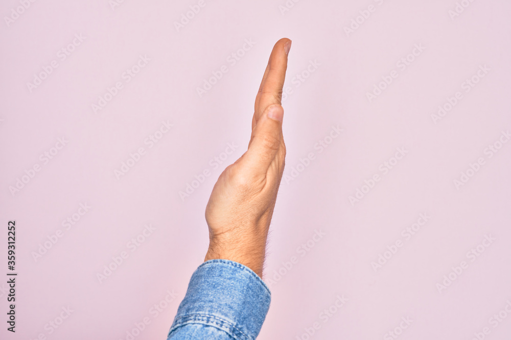 Wall mural hand of caucasian young man showing fingers over isolated pink background showing the side of stretc