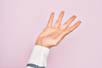 Hand of caucasian young man showing fingers over isolated pink background presenting with open palm, reaching for support and help, assistance gesture