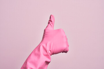 Hand of caucasian young man with cleaning glove over isolated pink background doing successful...