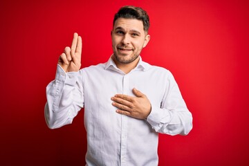 Young business man with blue eyes wearing elegant shirt standing over red isolated background...