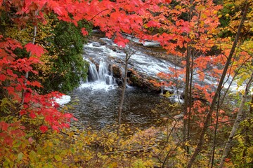 Michigan waterfall framed by vibrant fall colors on the Falls River in the Upper Peninsula town of L'Anse. 