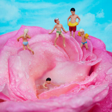 Ni&ntilde;os de modelismo en miniatura ba&ntilde;&aacute;ndose en el agua de una rosa