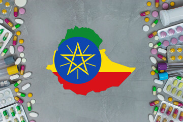 The Ethiopia State began research for treatment and medicine to combat the pandemic outbreak disease coronavirus. Medicine, pills, needles, syringes and Ethiopia map and flag on gray background.