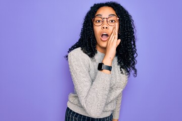 Fototapeta na wymiar Young african american woman wearing casual sweater and glasses over purple background hand on mouth telling secret rumor, whispering malicious talk conversation