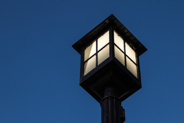 Illuminated retro style lamp post in horizontal orientation with copy space.