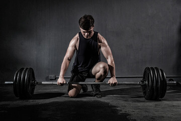 Strong fitness man doing arm workout with barbells in the gym