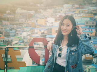 Young happy woman tourist in Gamcheon Culture Village, Busan, South Korea.