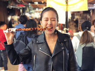 Young woman eating Steamed Octopus Legs at  at Myeong-dong street food, Seoul, South Korea